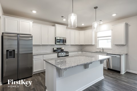 A kitchen with a granite countertop and a refrigerator.