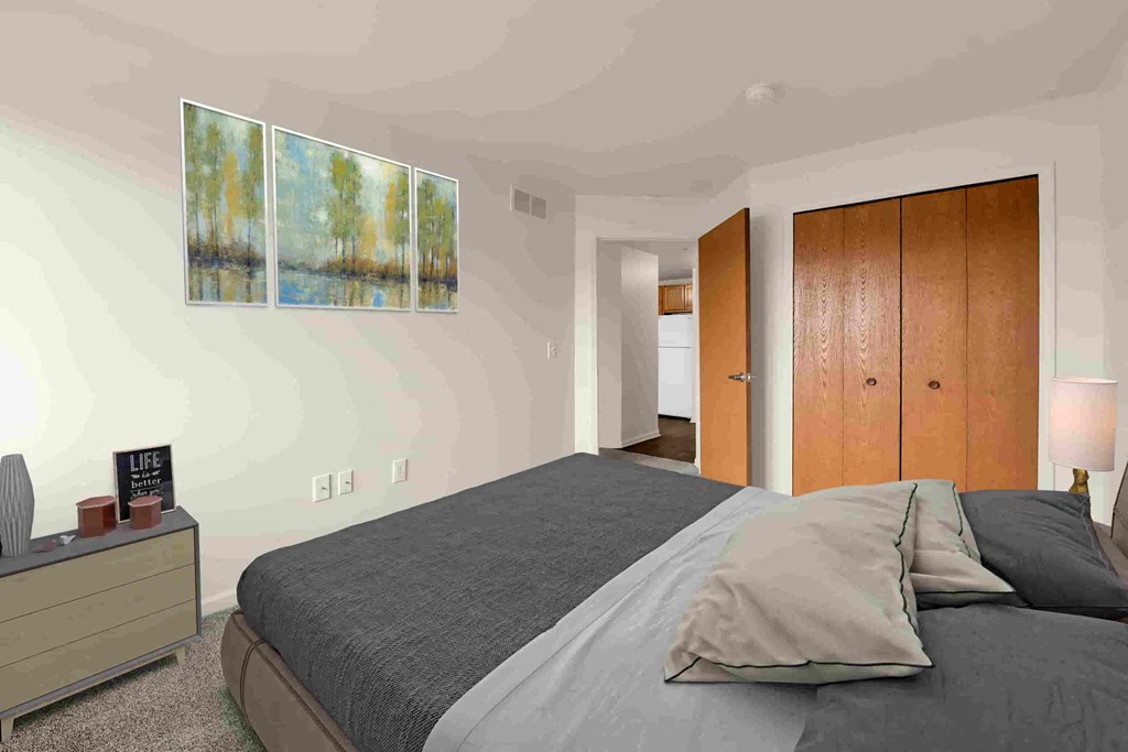 a bedroom with a bed and two paintings on the wall