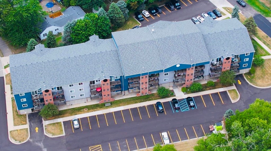 an aerial view of a building with cars parked in front of it
