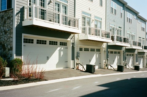 A row of townhouses with garages on the ground floor.