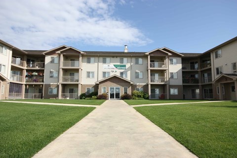 A large apartment complex with a walkway in front.