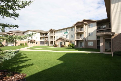 Apartment complex with green lawn in front.