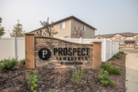 A sign for Prospect Tow Homes with a parking symbol on it.