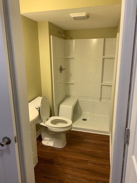 A white toilet is in a bathroom with yellow walls.