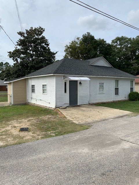 A small white house with a grey roof and a grey door.