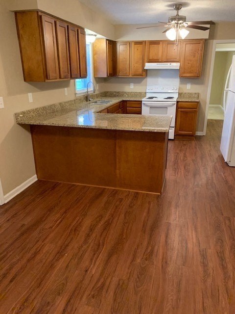A kitchen with wooden floors and a white fridge.
