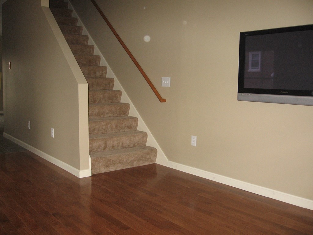 a staircase in a house with a tv on the wall