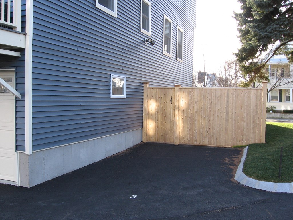 a wood privacy fence in front of a blue house
