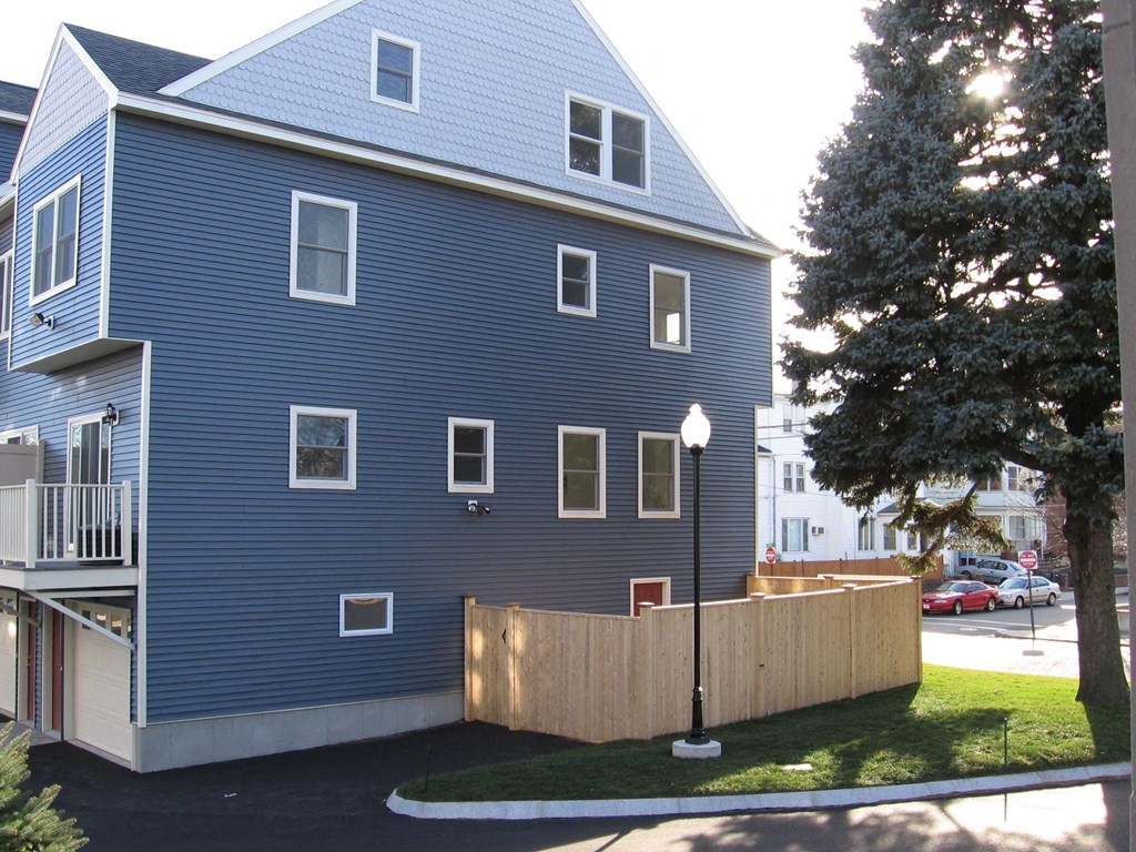 a blue house with a wooden fence in front of it