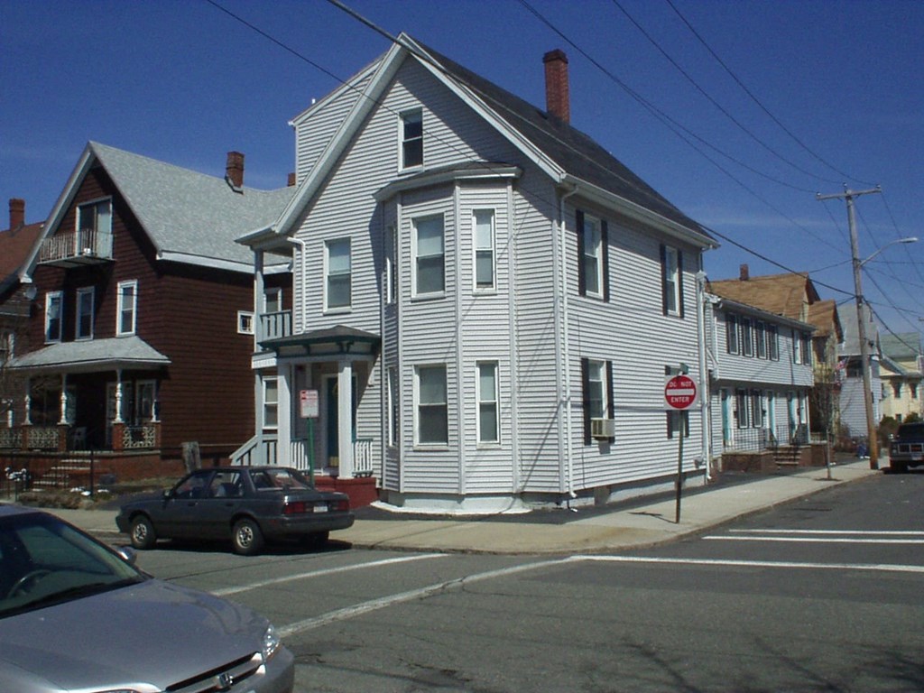 a white house on the corner of a street
