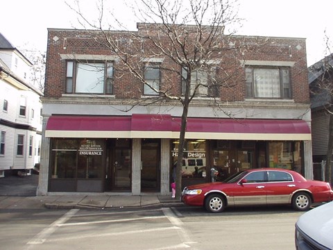 a red car parked in front of a store on a city street