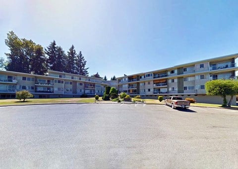 an empty parking lot in front of an apartment building