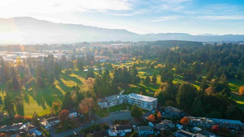 A sunny day in a small town with a large building in the center.