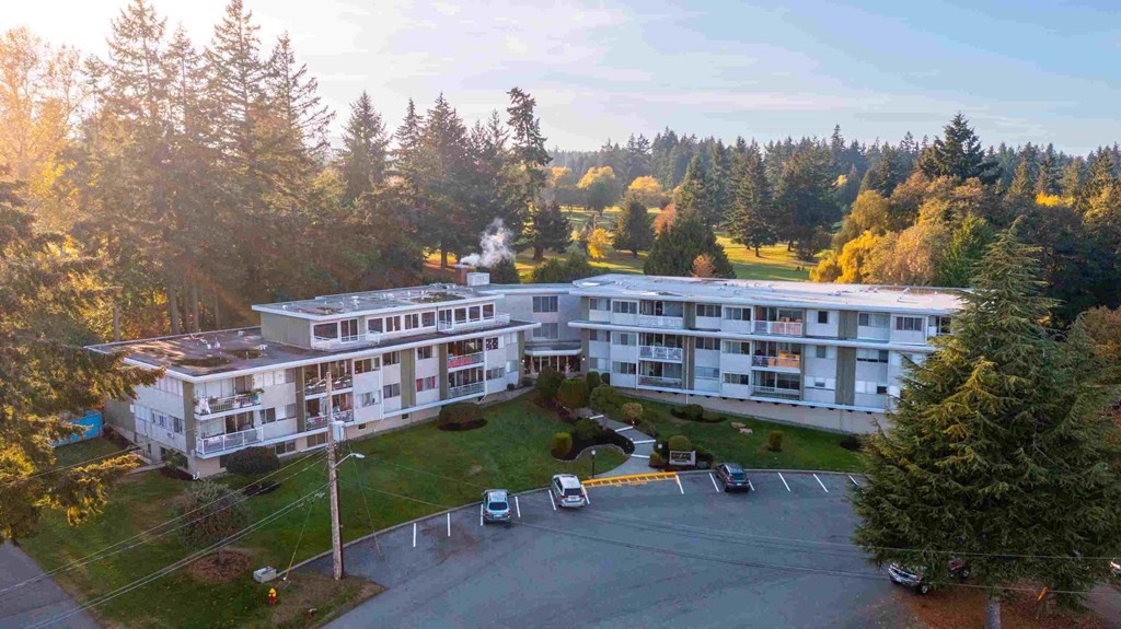 an aerial view of a large building with trees in the background