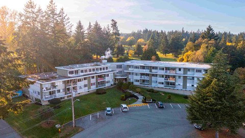 an aerial view of a large building with trees in the background