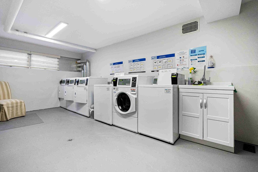 a row of washers and dryers in a laundry room