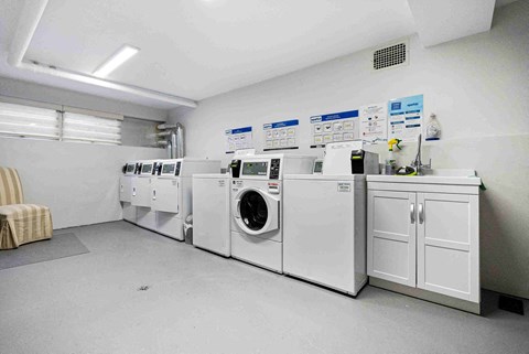 a row of washers and dryers in a laundry room