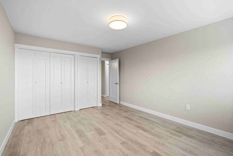 an empty living room with white walls and wood floors