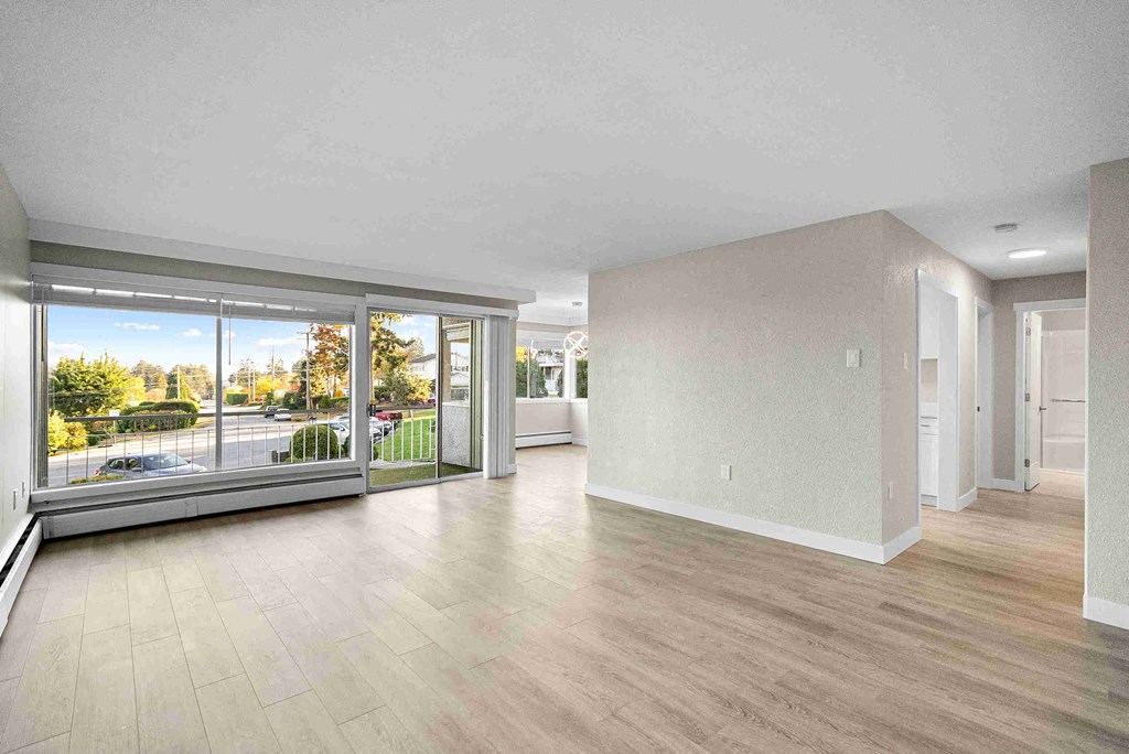 a living room with a large window and a wooden floor