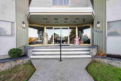 the front entrance of a home with a large glass door and stairs