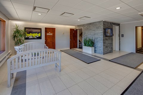 the lobby of a building with a white bench