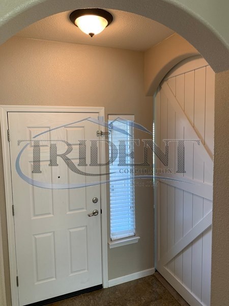 A white door is in a hallway with a light on the ceiling.