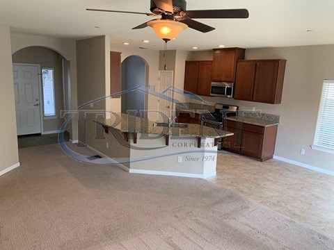 A spacious kitchen with a ceiling fan and a sign that says "Corporate Since 1974".