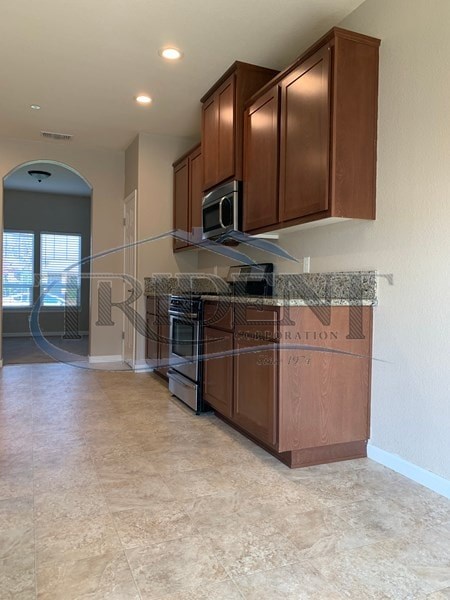 A kitchen with wooden cabinets and a granite countertop.