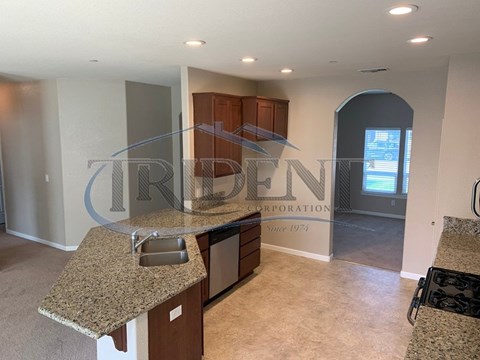 A kitchen with granite countertops and a sink is shown.