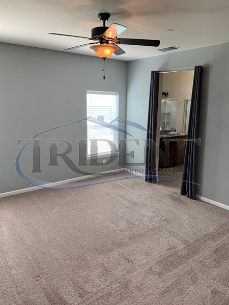 A room with a ceiling fan and carpeted floor.