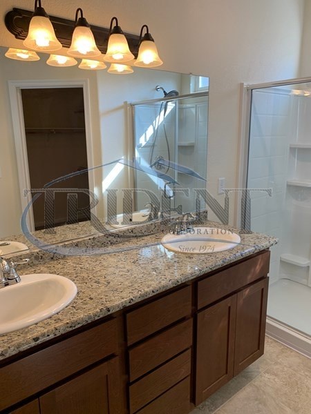 A bathroom with a granite countertop and a mirror above it.