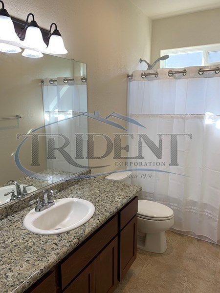A bathroom with a sink, toilet, and a shower curtain with the word "Trident" on it.