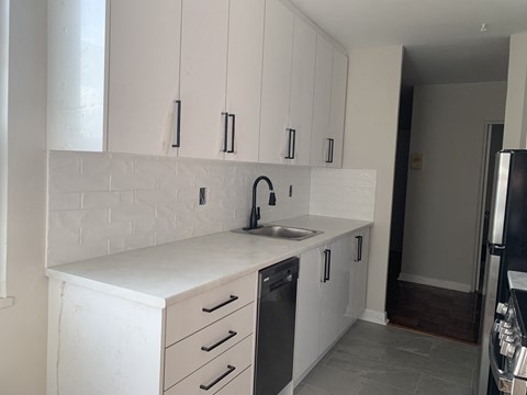 a white kitchen with white cabinets and a sink