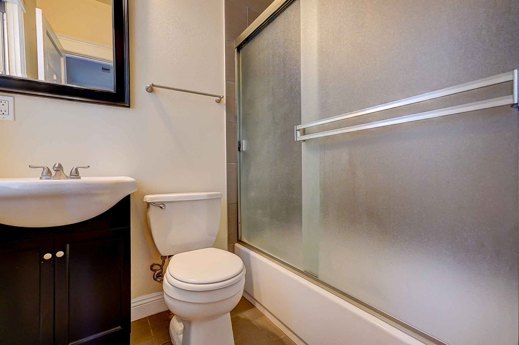 a bathroom with a shower and a toilet and a sink