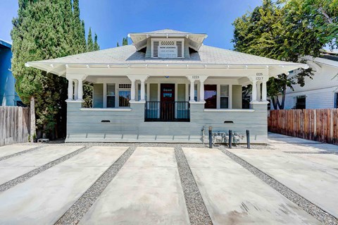 the front of a white house with a porch