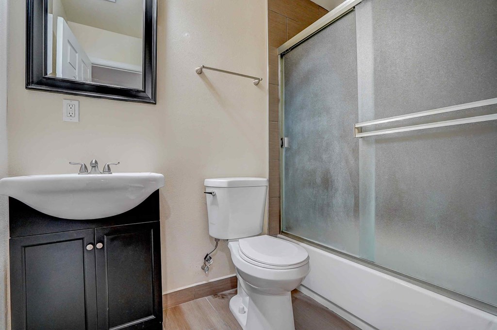 a bathroom with a toilet and a sink and a shower