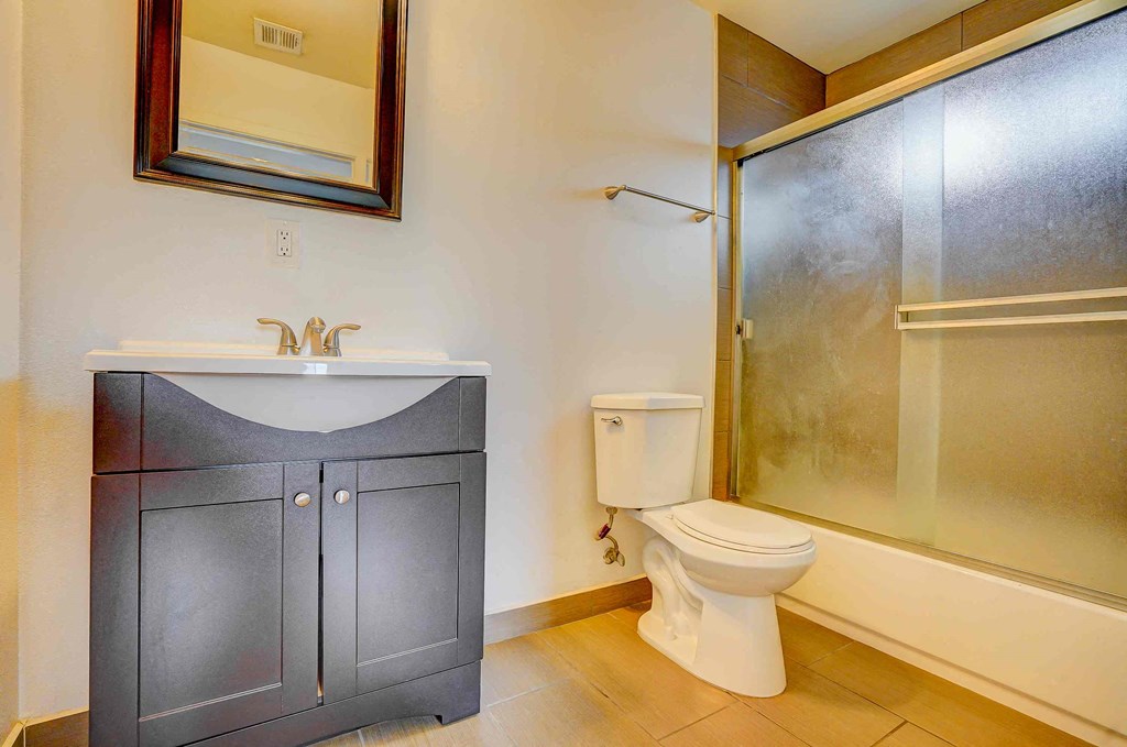 a bathroom with a toilet and a sink and a shower