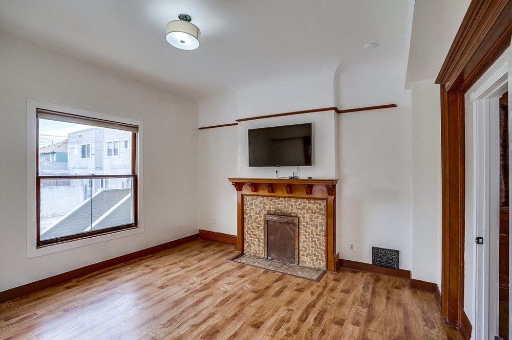an empty living room with a fireplace and a window