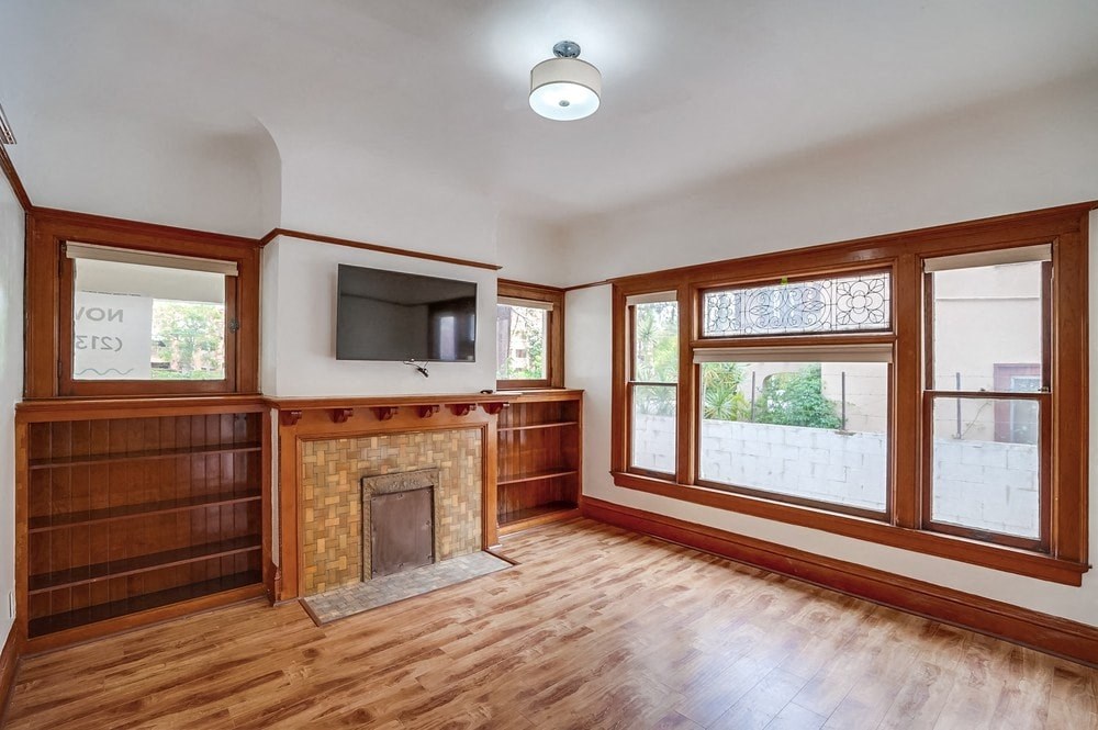 an empty living room with a fireplace and a tv