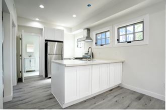 a kitchen with white cabinets and a white counter top