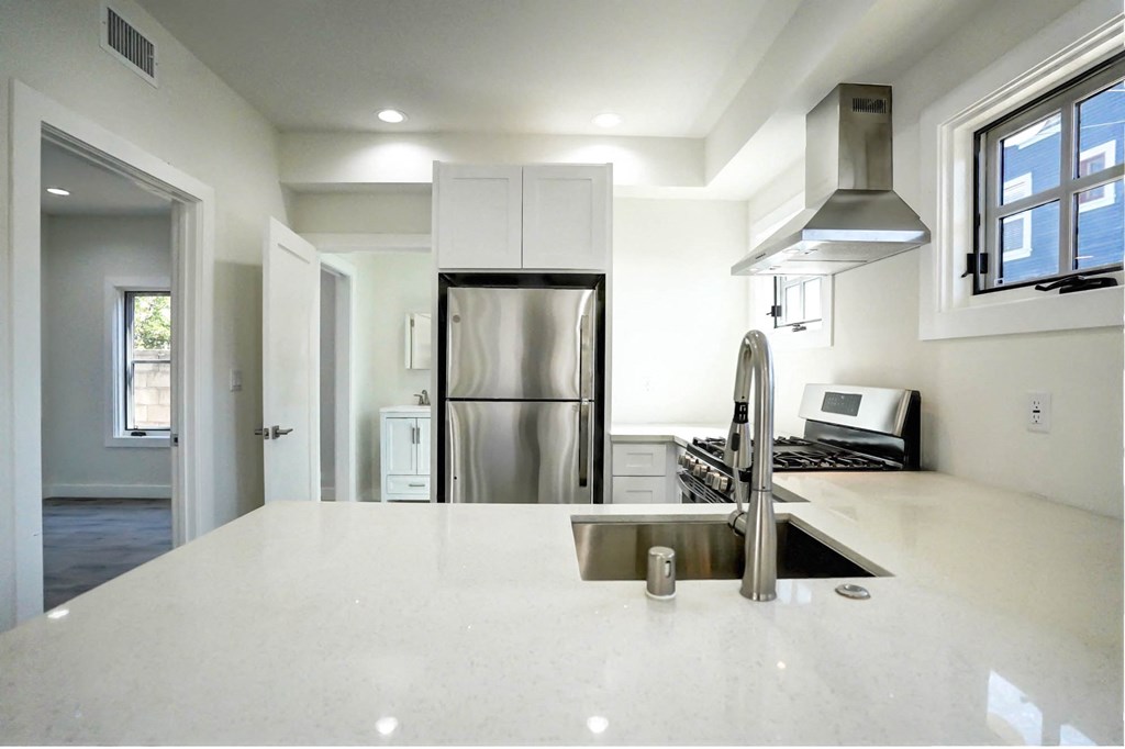 a white kitchen with a sink and a refrigerator