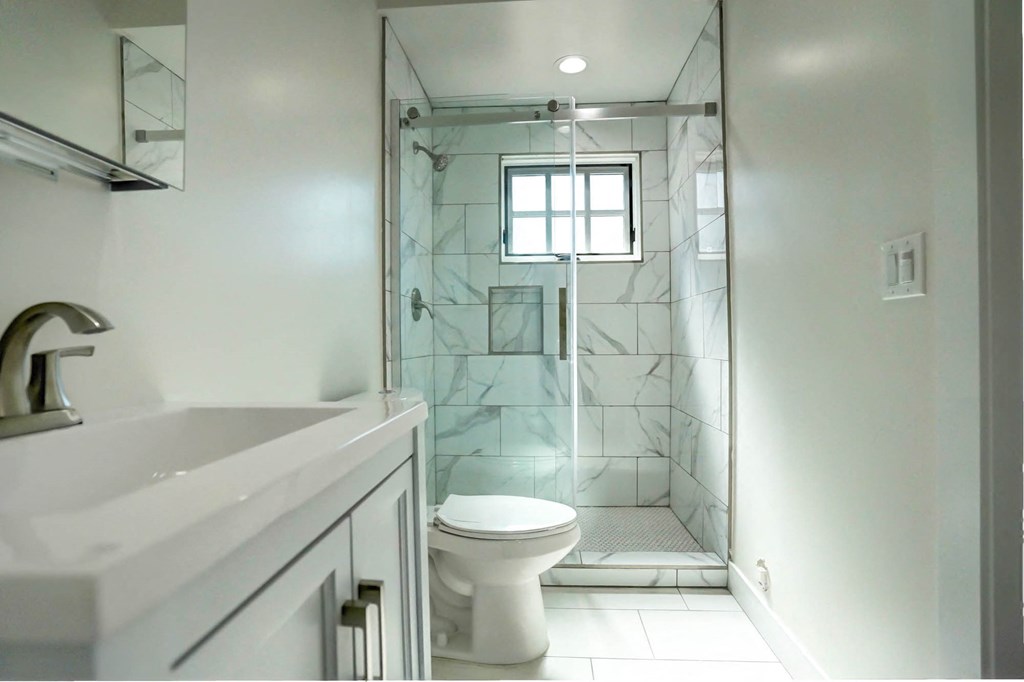 a bathroom with a shower and a sink and a toilet