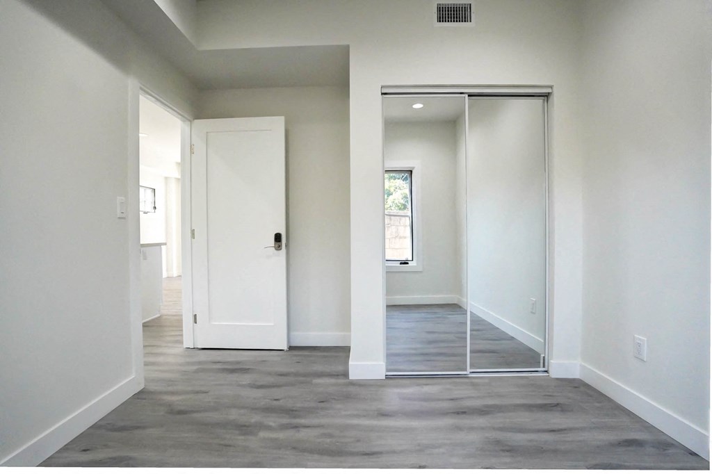 an empty room with white walls and a sliding glass door