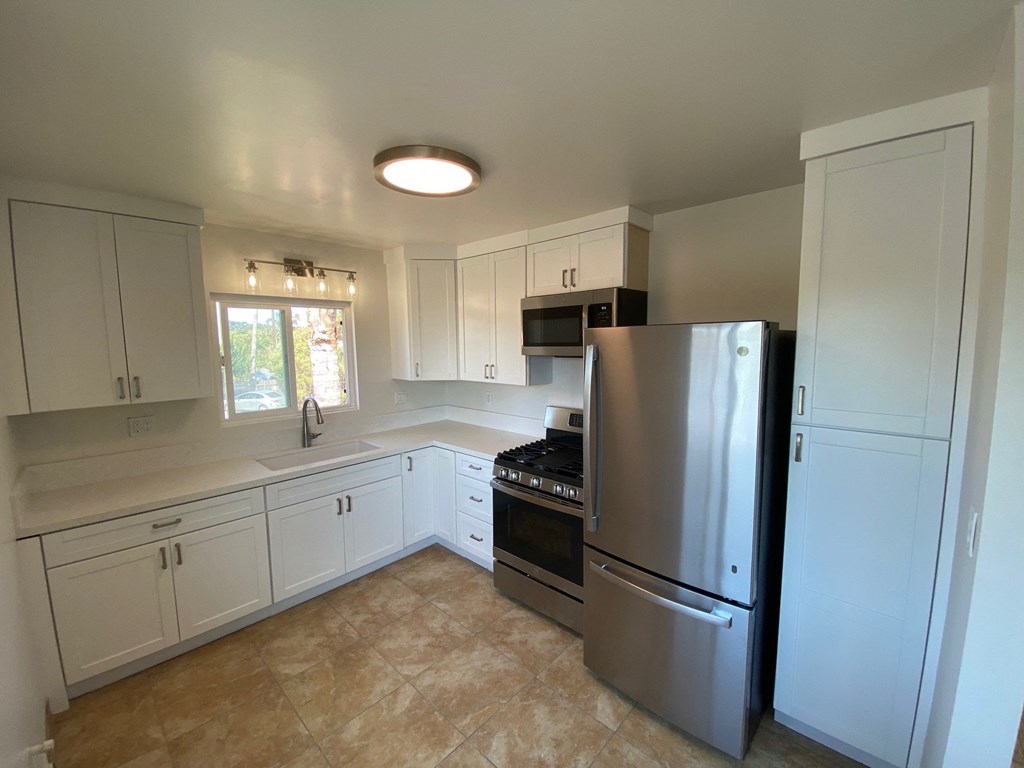 a kitchen with stainless steel appliances and white cabinets