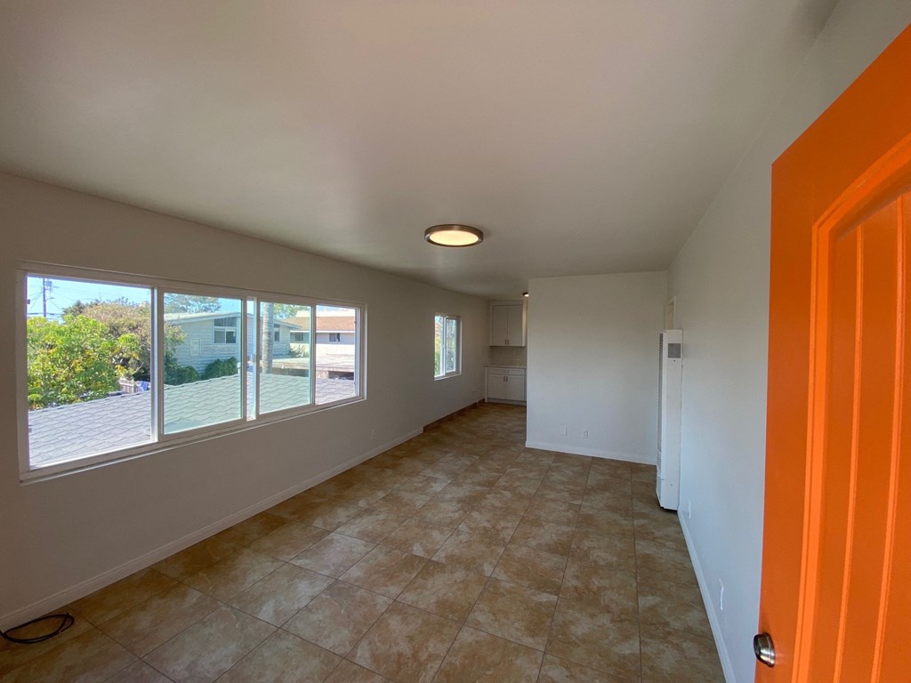 a room with a large window and a tile floor and an orange door