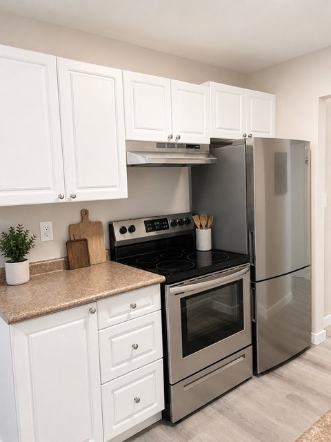 A kitchen with a stove top oven and a refrigerator.