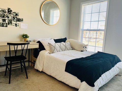 a bedroom with a bed and a desk with a mirror