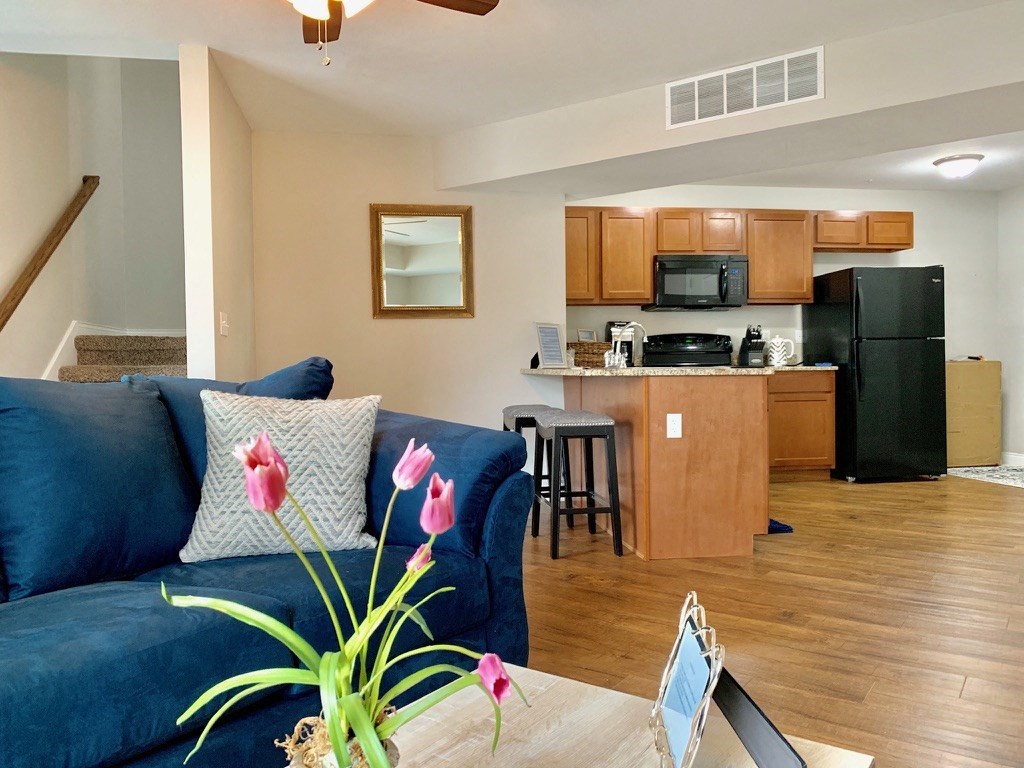 a living room with a blue couch and a kitchen