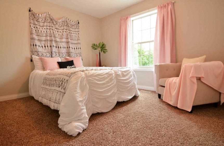 a bedroom with a bed and a chair and a window