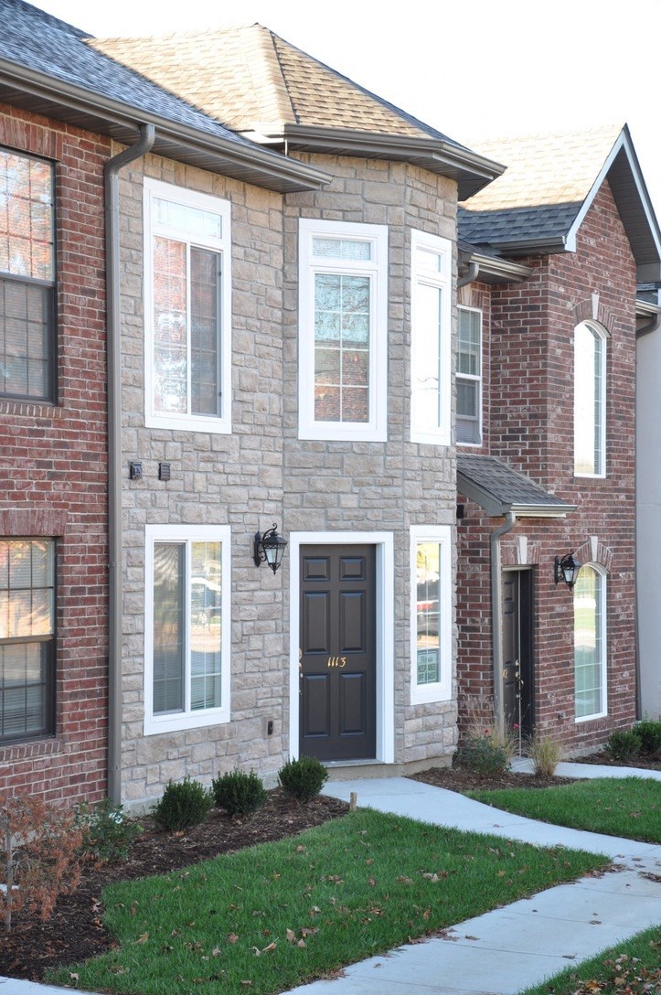 the front of a brick house with a black door